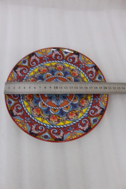 Two decorative Marrakech ceramic plates with vibrant colorful mosaic mandala patterns resting on a rustic wooden table.