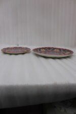 Two decorative Marrakech ceramic plates with vibrant colorful mosaic mandala patterns resting on a rustic wooden table.