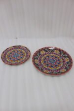 Two decorative Marrakech ceramic plates with vibrant colorful mosaic mandala patterns resting on a rustic wooden table.