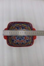 Three vibrant red Moroccan Marrakech decorative ceramic bowls with handles set on a wooden countertop