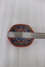 Three vibrant red Moroccan Marrakech decorative ceramic bowls with handles set on a wooden countertop