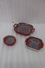 Three vibrant red Moroccan Marrakech decorative ceramic bowls with handles set on a wooden countertop