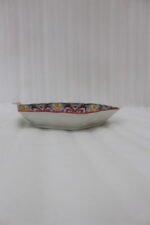 Hexagonal decorative Marakesh plate with vibrant hand-painted Moroccan tile mosaic pattern on a wooden kitchen table.