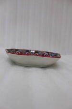 Colorful star-shaped ceramic Marrakesh decorative plate with intricate Moroccan mosaic pattern on a wooden table.