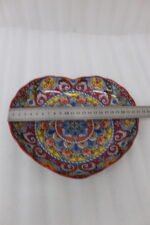 Decorative Marrakesh serving plate featuring vibrant hand-painted mosaic mandala patterns on a wooden countertop.