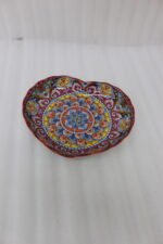 Decorative Marrakesh serving plate featuring vibrant hand-painted mosaic mandala patterns on a wooden countertop.