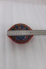 4-inch hand-painted decorative Marrakech ceramic piyali bowl with vibrant blue, yellow, and red pattern resting on a wooden table.