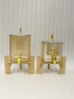 Ribbed amber glass beverage dispenser with gold tap and pineapple lid finial on a wooden stand