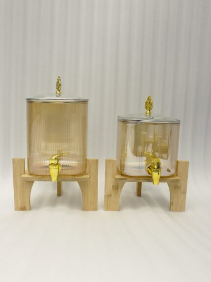 Ribbed amber glass beverage dispenser with gold tap and pineapple lid finial on a wooden stand
