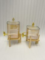 Ribbed amber glass beverage dispenser with gold tap and pineapple lid finial on a wooden stand