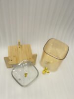 Ribbed amber glass beverage dispenser with gold tap and pineapple lid finial on a wooden stand