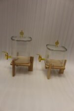 Two ribbed glass beverage dispensers with gold spigots on wooden stands sitting on a kitchen countertop