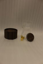 Elegant 3L ribbed glass drink dispenser sitting on a dark wooden base with a gold spigot on a kitchen counter