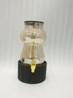 3.2L fluted amber glass beverage dispenser with wooden lid, wooden base, and gold spigot on a kitchen counter