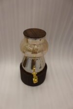3.2L fluted amber glass beverage dispenser with wooden lid, wooden base, and gold spigot on a kitchen counter