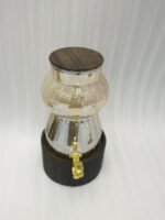 3.2L fluted amber glass beverage dispenser with wooden lid, wooden base, and gold spigot on a kitchen counter