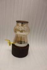 3.2L fluted amber glass beverage dispenser with wooden lid, wooden base, and gold spigot on a kitchen counter