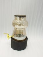 3.2L fluted amber glass beverage dispenser with wooden lid, wooden base, and gold spigot on a kitchen counter