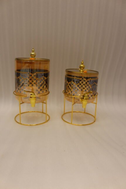 Luxury amber glass beverage dispenser with intricate blue pattern on a decorative gold metal stand