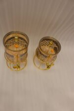 Luxury amber glass beverage dispenser with intricate blue pattern on a decorative gold metal stand