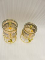 Luxury amber glass beverage dispenser with intricate blue pattern on a decorative gold metal stand