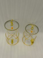 Two luxury clear glass beverage dispensers with gold deer lid handles and matching metallic stands on a marble countertop