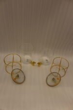 Two luxury clear glass beverage dispensers with gold deer lid handles and matching metallic stands on a marble countertop