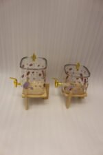 Two strawberry pattern glass drink dispensers with gold spigots set on wooden stands in a bright kitchen context.