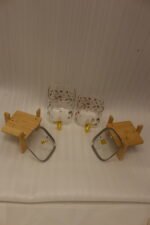 Two square glass beverage dispensers with fruit prints, gold spigots, and wooden stands on a kitchen counter