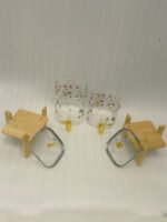 Two square glass beverage dispensers with fruit prints, gold spigots, and wooden stands on a kitchen counter
