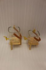 Ribbed glass beverage dispenser with leather carrying handle and gold spigot set on a wooden stand
