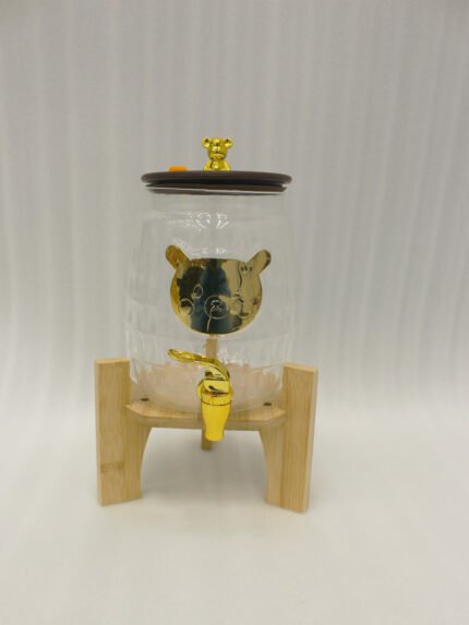 3.5 liter ribbed glass beverage dispenser with polished gold base, lid, and spigot on a kitchen counter