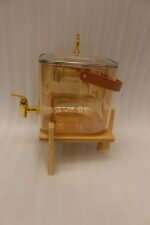 6.5L amber shaded glass beverage dispenser with gold spigot on a wooden stand
