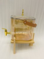 6.5L amber shaded glass beverage dispenser with gold spigot on a wooden stand