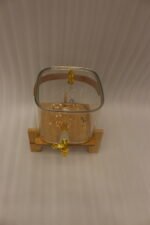 6.5-liter clear glass beverage dispenser with a gold spigot set on a raised wooden stand on a marble countertop