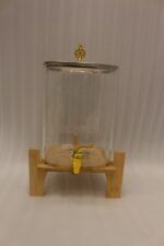 Clear 9.5L glass beverage dispenser with gold spigot on a wooden stand on a white marble countertop