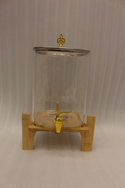 Clear 9.5L glass beverage dispenser with gold spigot on a wooden stand on a white marble countertop