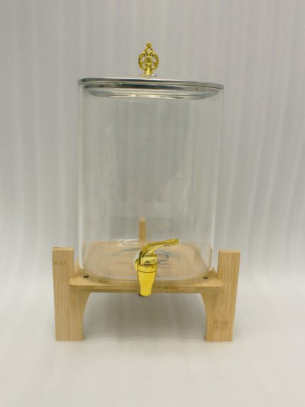 Clear 9.5L glass beverage dispenser with gold spigot on a wooden stand on a white marble countertop