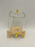 Clear 9.5L glass beverage dispenser with gold spigot on a wooden stand on a white marble countertop