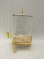 Clear 9.5L glass beverage dispenser with gold spigot on a wooden stand on a white marble countertop