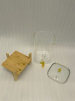 Clear 9.5L glass beverage dispenser with gold spigot on a wooden stand on a white marble countertop