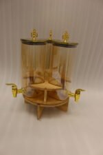 3-piece amber shaded glass beverage dispenser set with gold spigots on a wooden stand