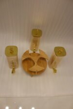 3-piece amber shaded glass beverage dispenser set with gold spigots on a wooden stand