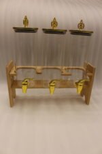Triple clear acrylic beverage dispenser set on a wooden stand with gold spigots and decorative finial tops on a kitchen counter