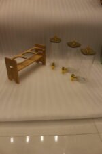 Triple clear acrylic beverage dispenser set on a wooden stand with gold spigots and decorative finial tops on a kitchen counter