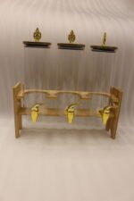 An elegant 3-tier beverage dispenser set featuring clear glass canisters with gold spigots and lids, resting on a natural bamboo stand on a white marble countertop.