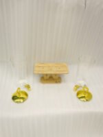 Two tall clear glass drink dispensers with gold spigots and circular gold finial lids resting on a wooden W-shaped stand.
