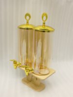 Dual 3.3L amber shaded glass beverage dispensers with gold lids and spigots on a W-shaped wooden stand sitting on a modern kitchen counter.