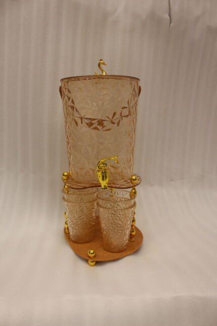 Elegant pink acrylic beverage dispenser with gold swan finial, gold spigot, stand, and 6 matching diamond-cut glasses.