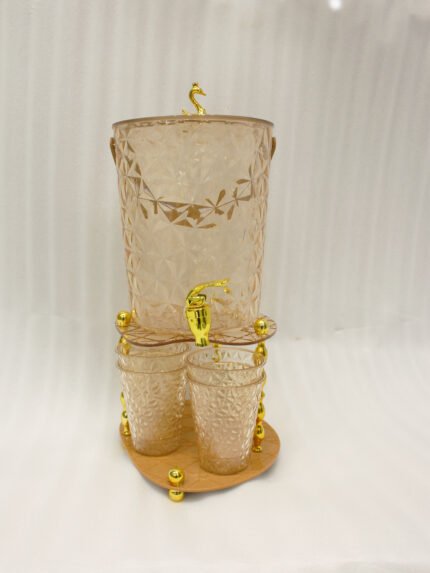 Elegant pink acrylic beverage dispenser with gold swan finial, gold spigot, stand, and 6 matching diamond-cut glasses.